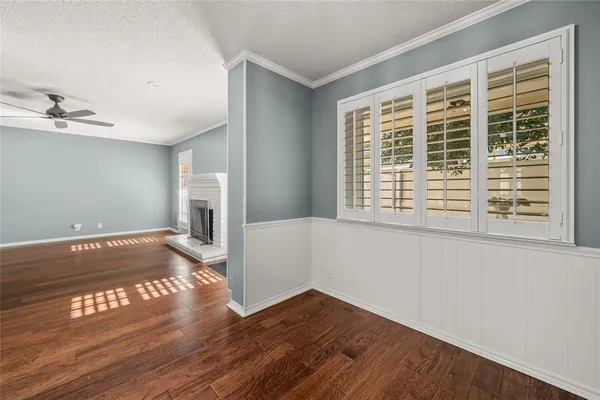 a view of an empty room with window and wooden floor
