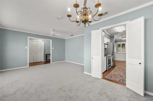 wooden floor in an empty room with a chandelier