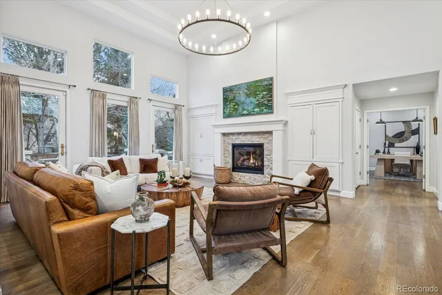 a living room with furniture a fireplace and a large window