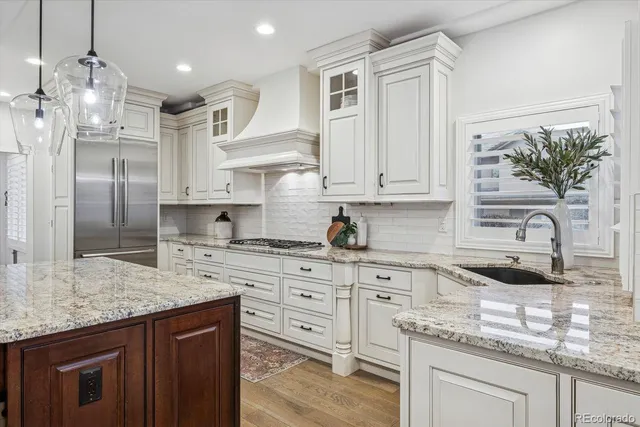 a kitchen with stainless steel appliances granite countertop a sink a stove and a refrigerator