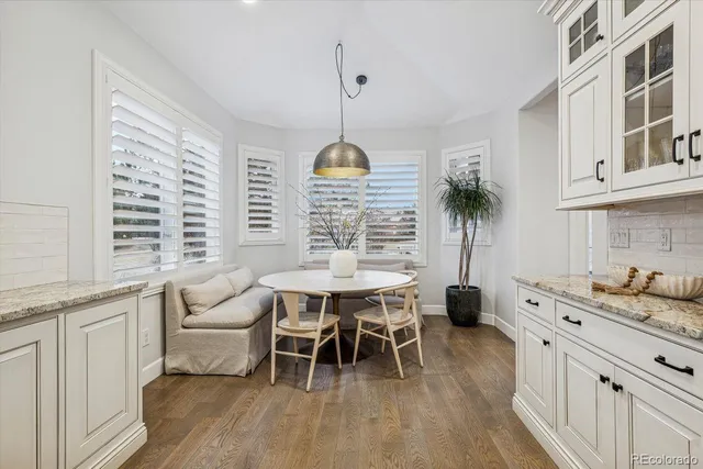 a dining room with furniture a chandelier and wooden floor