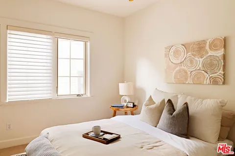 a bedroom with a bed and dresser with mirror