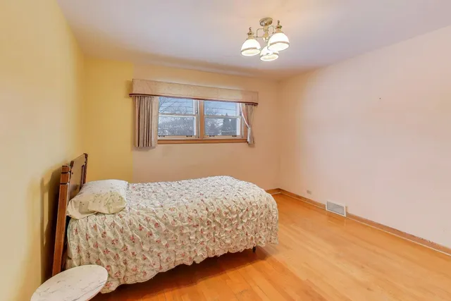 a bedroom with a bed and a chandelier