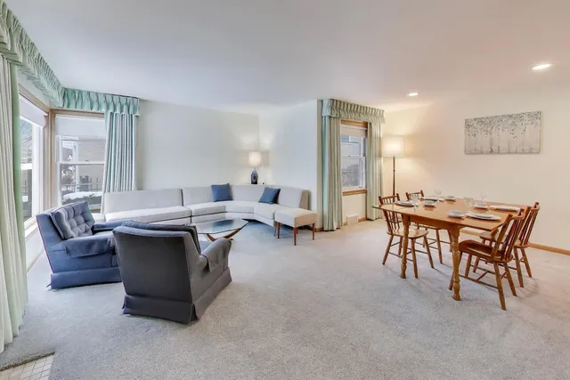 a living room with furniture a table and a large window