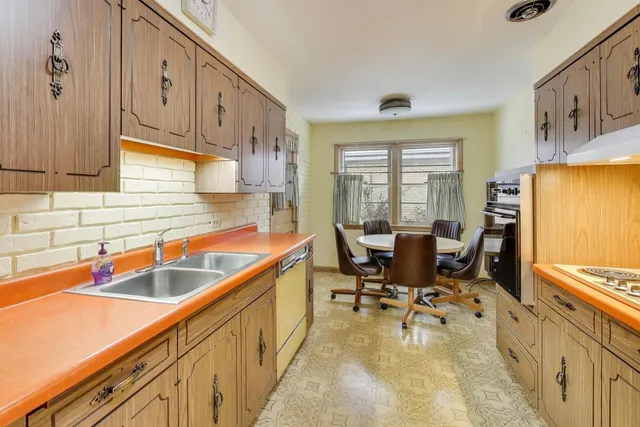 a kitchen with stainless steel appliances granite countertop sink stove top oven and cabinets