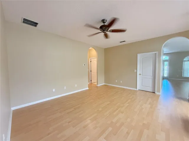 a view of a big room with wooden floor and a ceiling fan