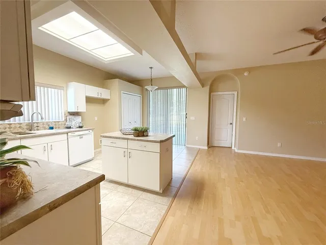 a kitchen with white cabinets and sink