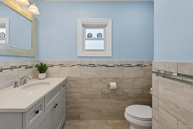 a bathroom with a sink a toilet and a mirror