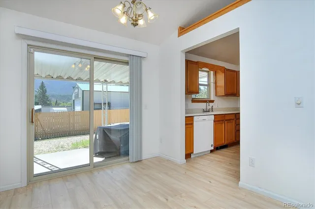 a view of a hallway with wooden floor and a kitchen