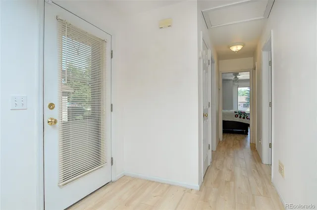 a view of a hallway with wooden floor and a bathroom