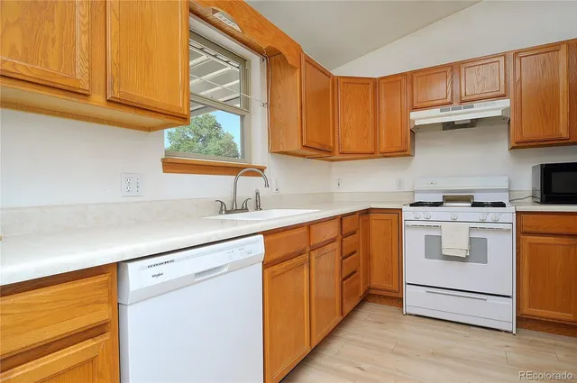 a kitchen with white cabinets and white appliances