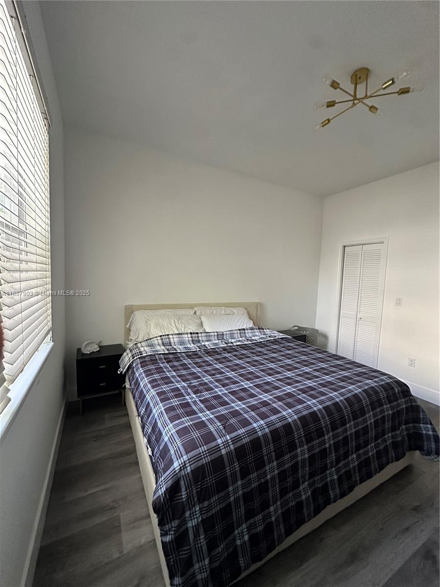 3067 Center Street, Unit 17 Miami, FL 33133 - Photo 12 of 21 a bedroom with a bed wooden floor and window
