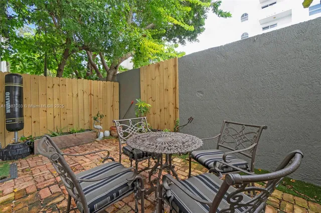 a view of a patio with table and chairs with wooden fence