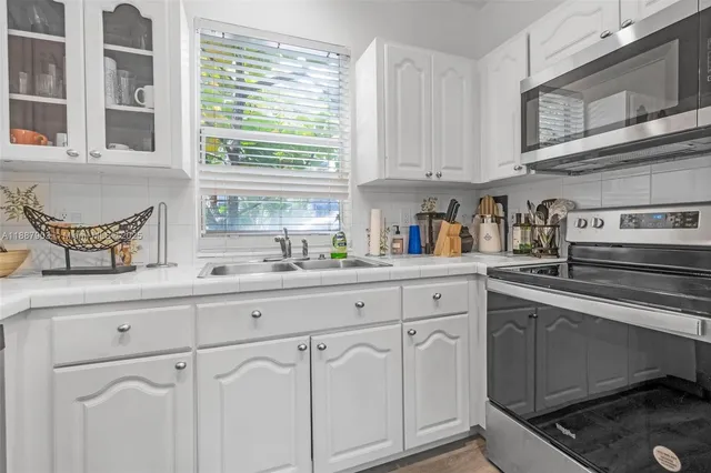 a kitchen with white cabinets and white appliances