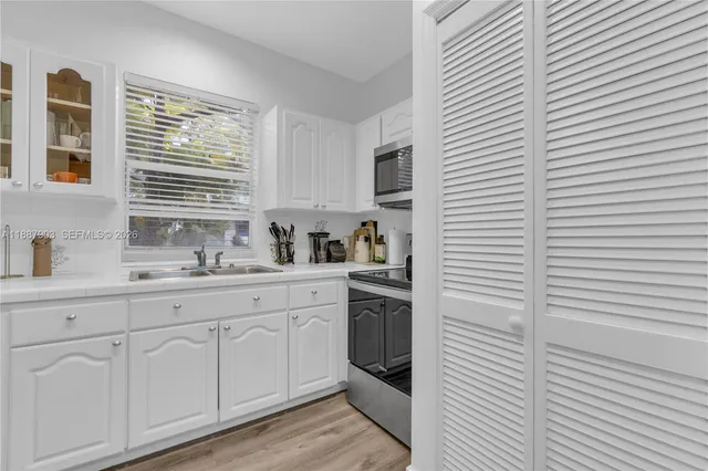 a kitchen with a sink cabinets and window