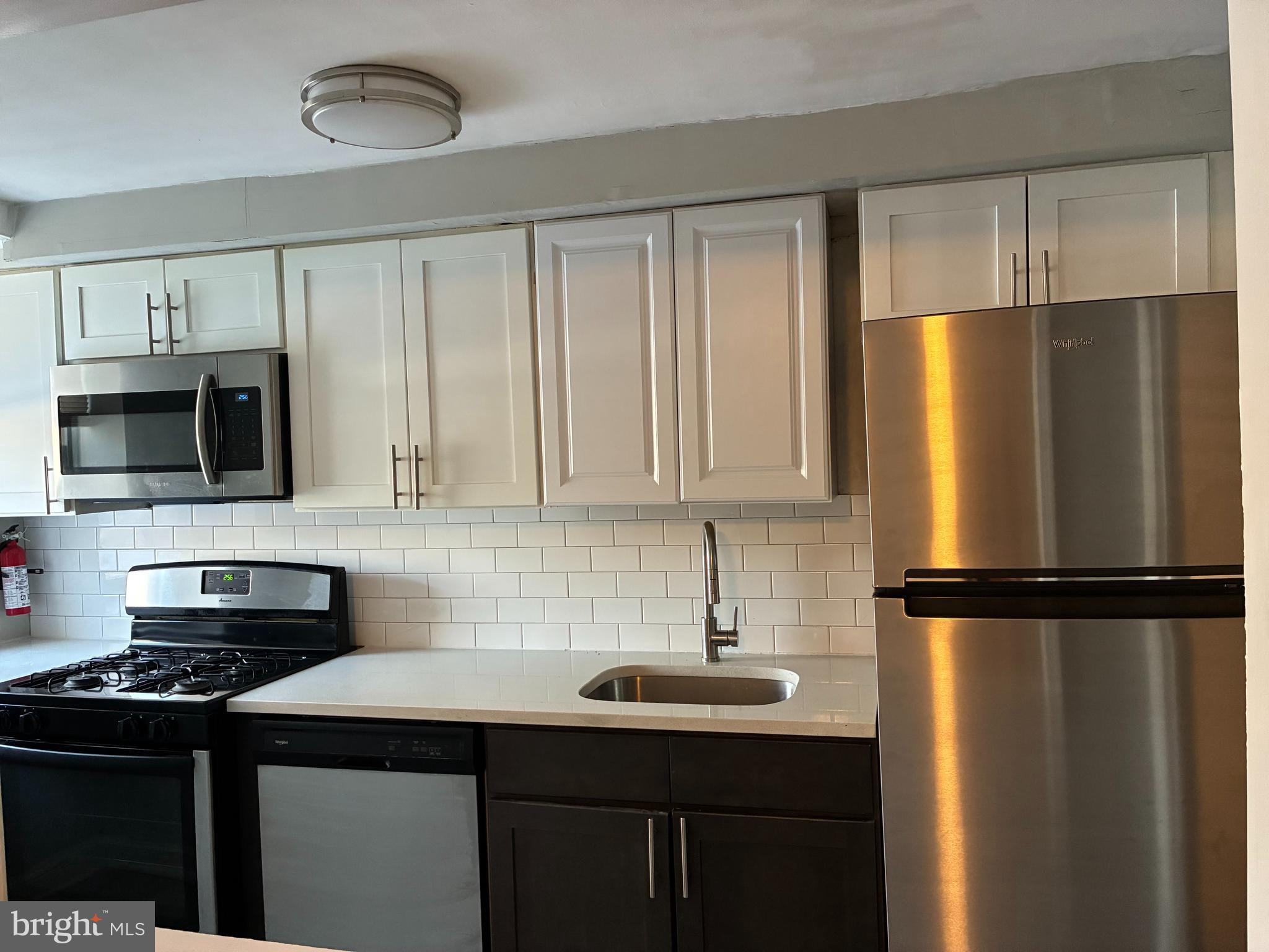 1800 Garrett Road, Unit B1 Lansdowne, PA 19050 - Photo 4 of 8 a kitchen with stainless steel appliances a refrigerator sink and microwave