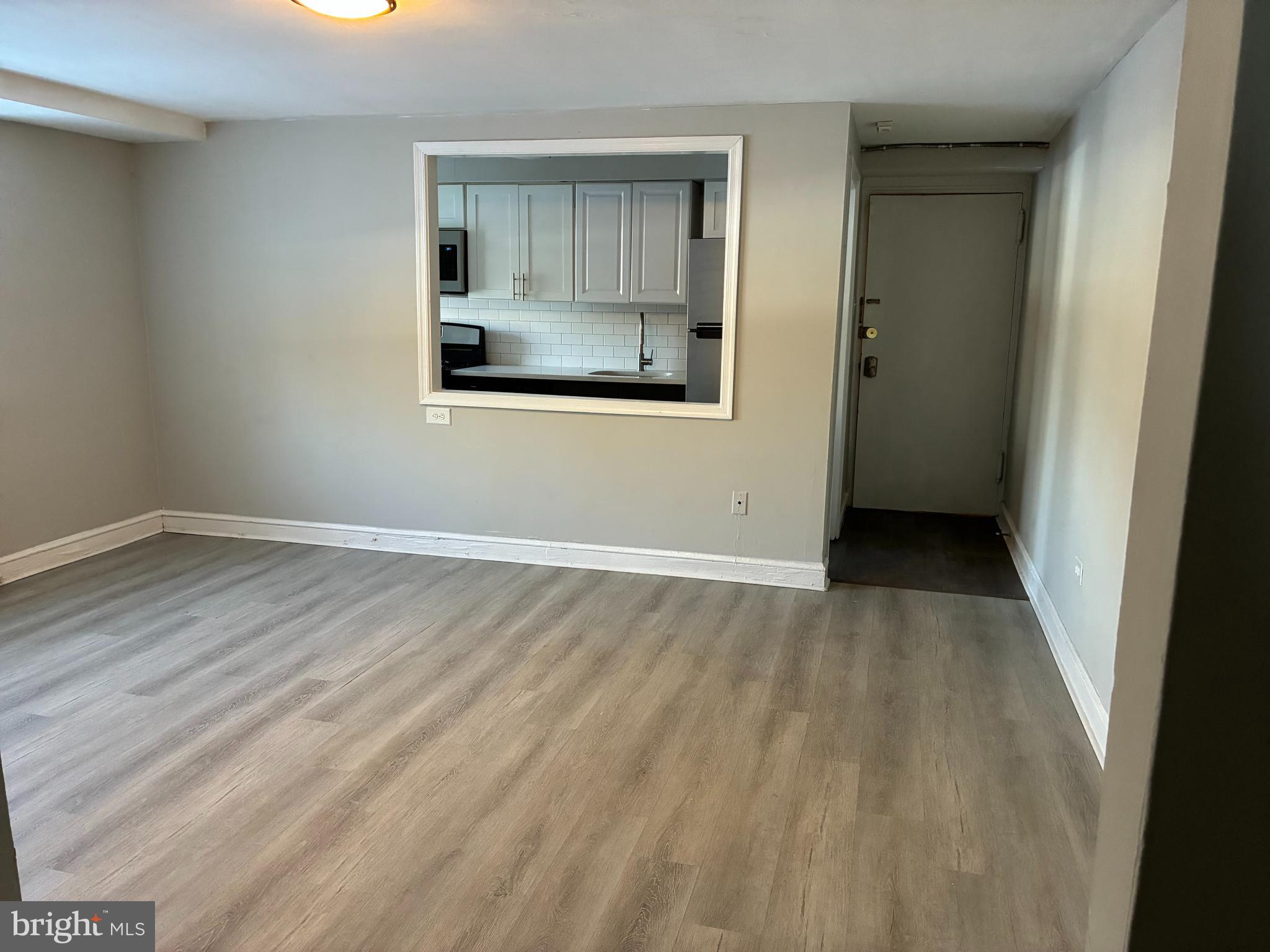 1800 Garrett Road, Unit B1 Lansdowne, PA 19050 - Photo 5 of 8 a view of an empty room with wooden floor and a window