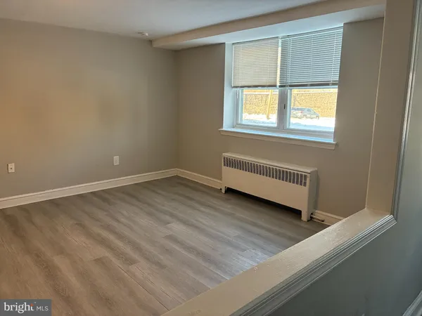 a view of a room with wooden floor and a window