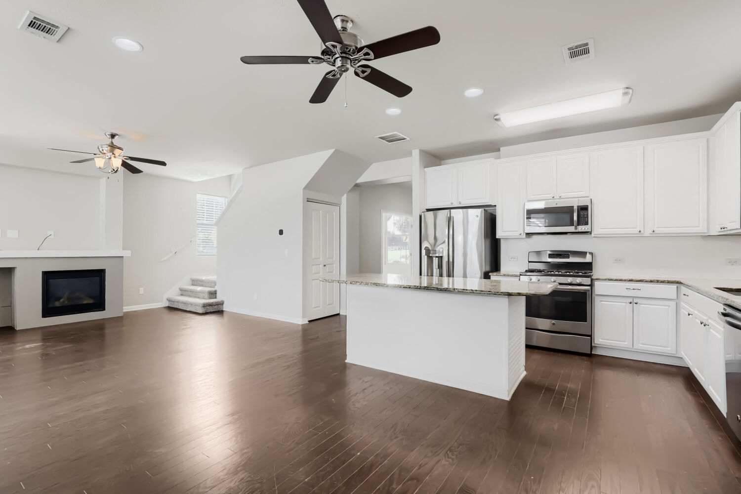 5136 Hellman Kyle, TX 78640 - Photo 8 of 25 a kitchen with stainless steel appliances white cabinets and a fireplace