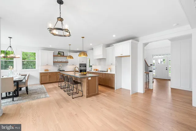 a large kitchen with stainless steel appliances granite countertop a sink a stove and a wooden floors