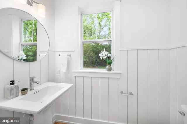 a living room with furniture mirror and a fireplace