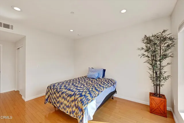 a bedroom with a bed and a potted plant