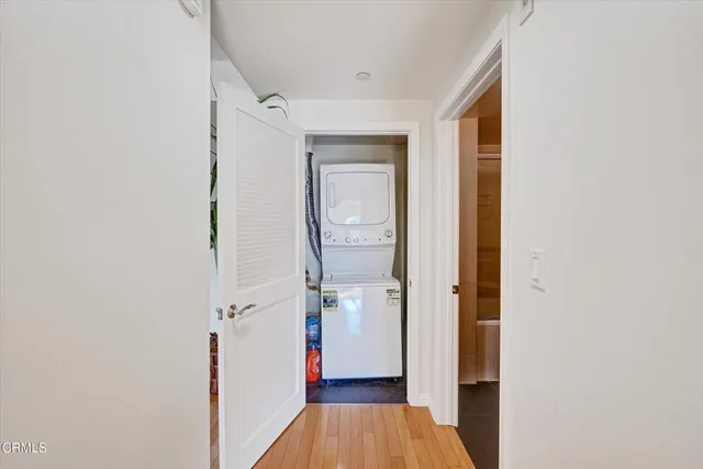 a view of a hallway with wooden floor and a bathroom