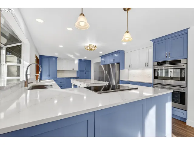 a kitchen with kitchen island a sink appliances and cabinets