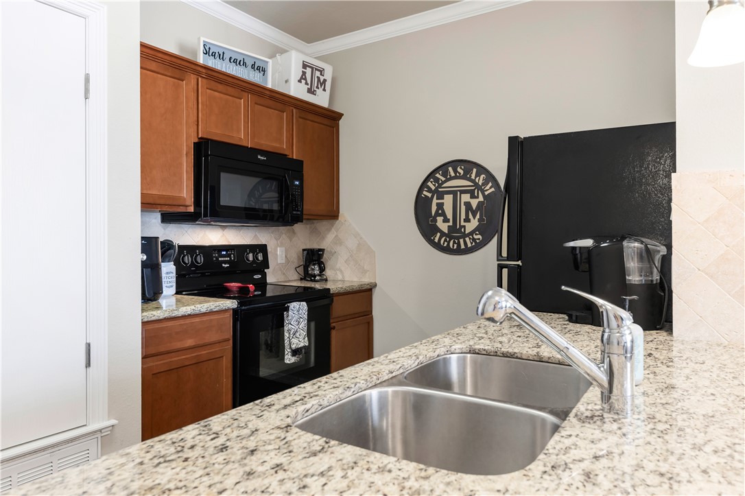1198 Jones-Butler Road, Unit 1806 College Station, TX 77840 - Photo 11 of 26 a kitchen with a sink cabinets and a stove top oven