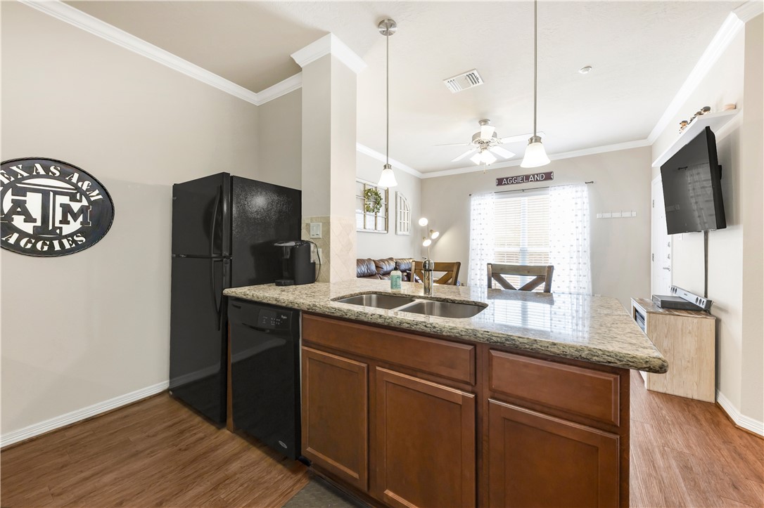 1198 Jones-Butler Road, Unit 1806 College Station, TX 77840 - Photo 14 of 26 a kitchen with stainless steel appliances granite countertop a refrigerator a oven and a sink with wooden floor