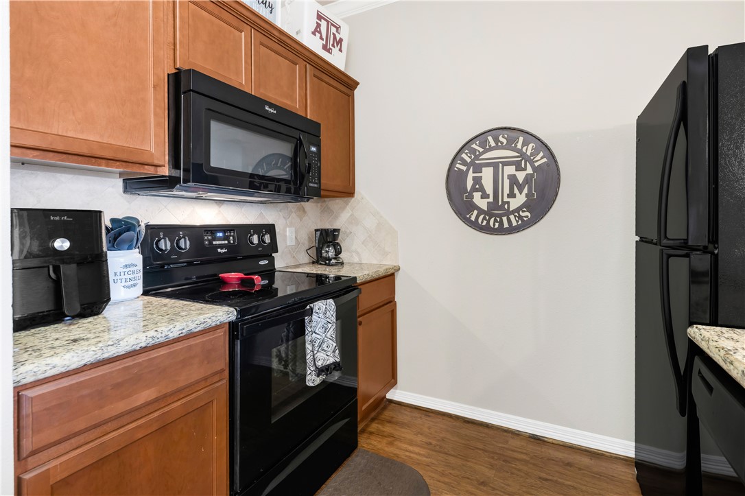 1198 Jones-Butler Road, Unit 1806 College Station, TX 77840 - Photo 17 of 26 a kitchen with stainless steel appliances granite countertop a stove and a microwave