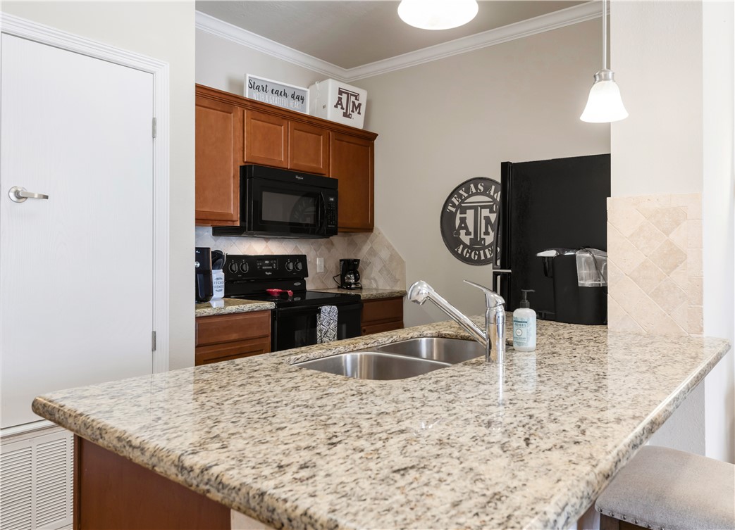 1198 Jones-Butler Road, Unit 1806 College Station, TX 77840 - Photo 10 of 26 a kitchen with stainless steel appliances kitchen island granite countertop a sink and a microwave