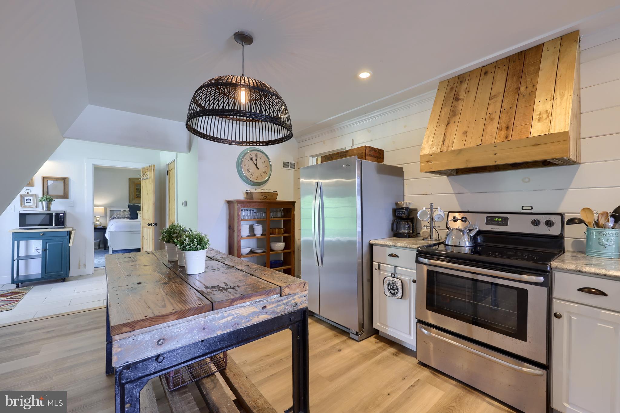 1770 Windy Hill Road Lancaster, PA 17602 - Photo 15 of 43 a kitchen with stainless steel appliances granite countertop a stove a refrigerator a sink a dining table and chairs with wooden floor