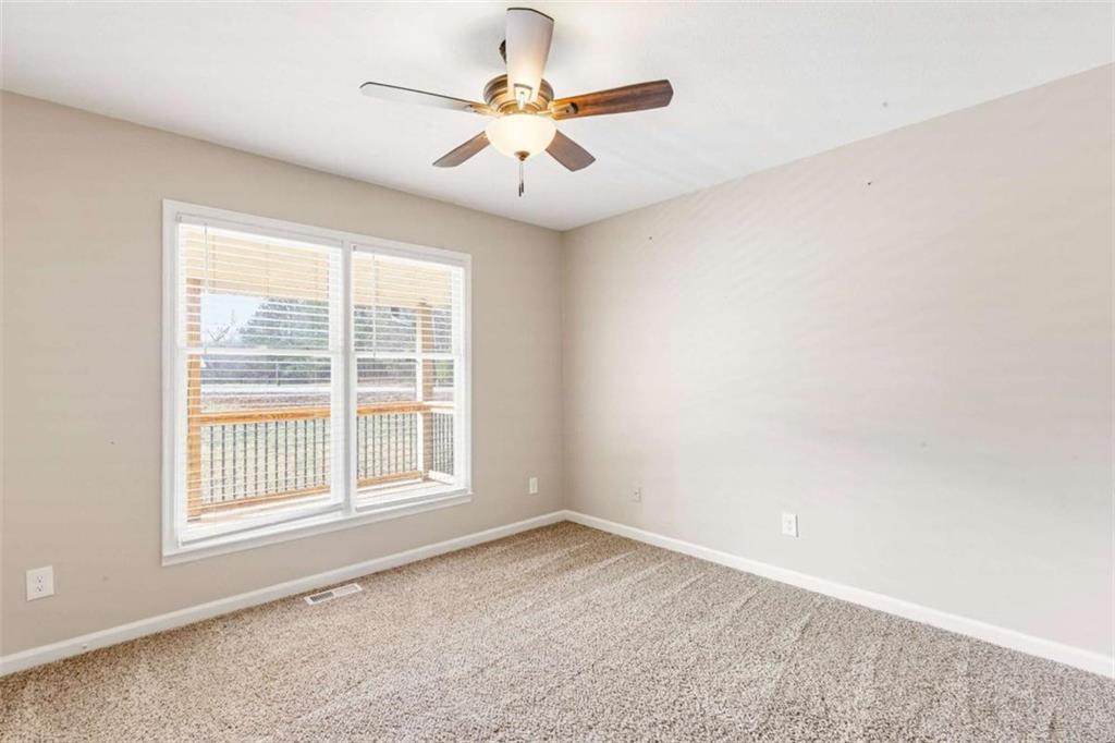 616 Wells Road Buchanan, GA 30113 - Photo 27 of 44 an empty room with chandelier fan and windows
