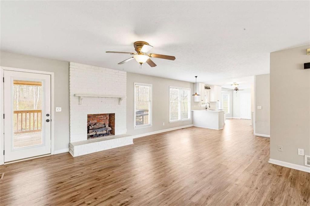616 Wells Road Buchanan, GA 30113 - Photo 8 of 44 a view of a kitchen with a sink a fireplace and wooden floor