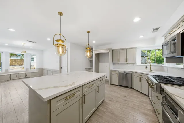 a kitchen with a stove a sink and chandelier