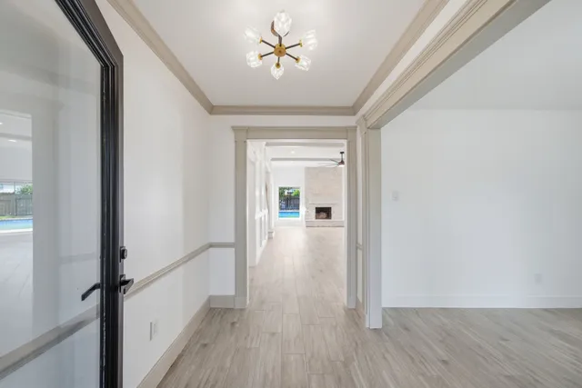 a view of a hallway with wooden floor and a chandelier