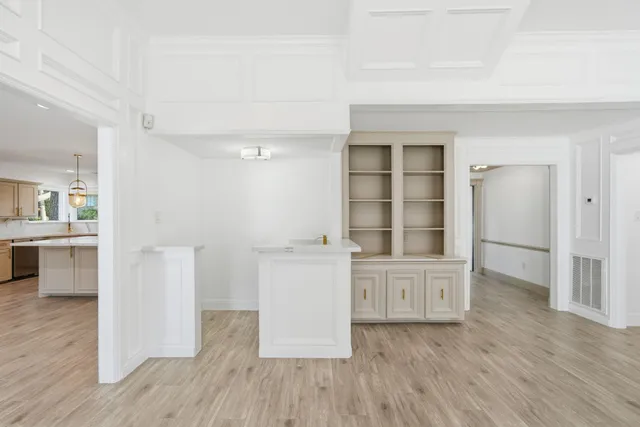 an empty room with wooden floor and cabinet