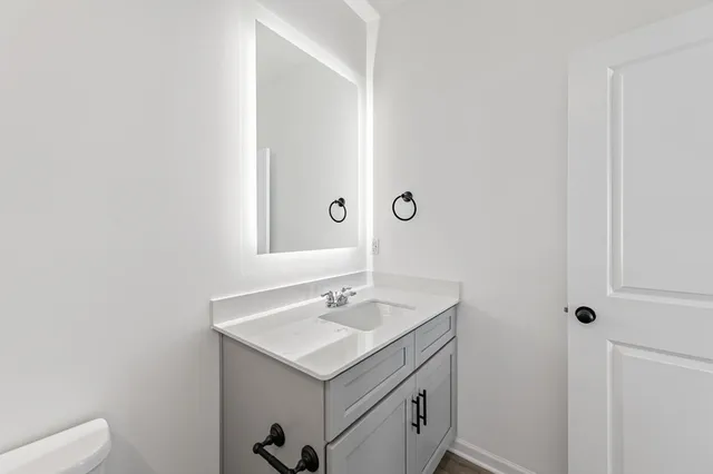 a kitchen with stainless steel appliances granite countertop a sink dishwasher a stove and a refrigerator with wooden floor