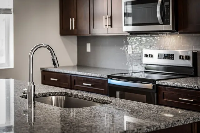 a kitchen with granite countertop a sink and a stove