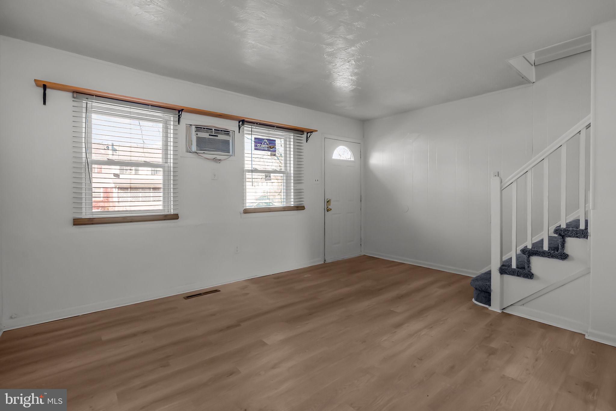 5708 Mitchell Road Levittown, PA 19057 - Photo 11 of 23 a view of an empty room with wooden floor and a window