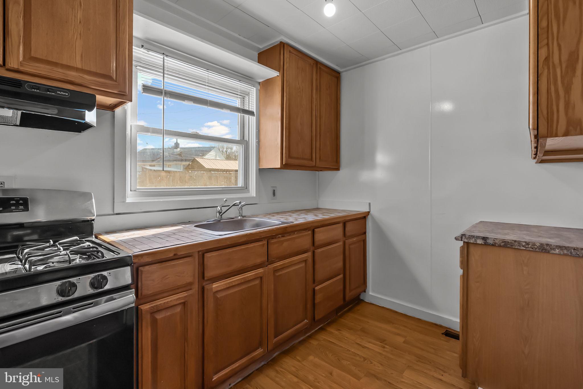 5708 Mitchell Road Levittown, PA 19057 - Photo 13 of 23 a kitchen with stainless steel appliances a stove a sink and a microwave