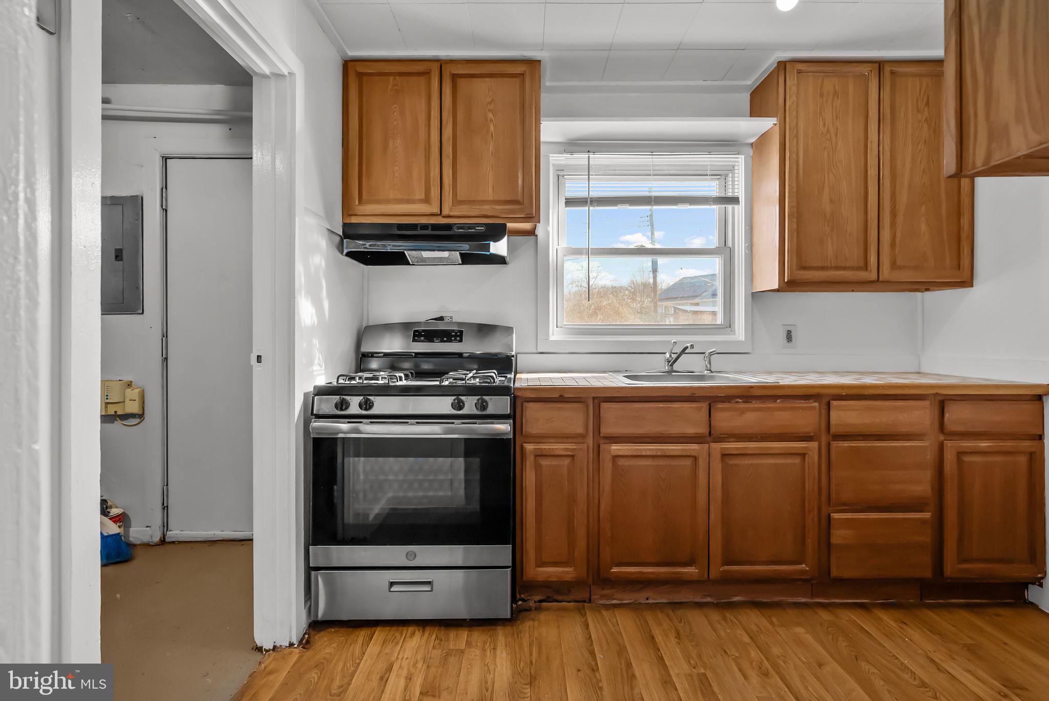 5708 Mitchell Road Levittown, PA 19057 - Photo 14 of 23 a kitchen with granite countertop wooden cabinets and a stove top oven