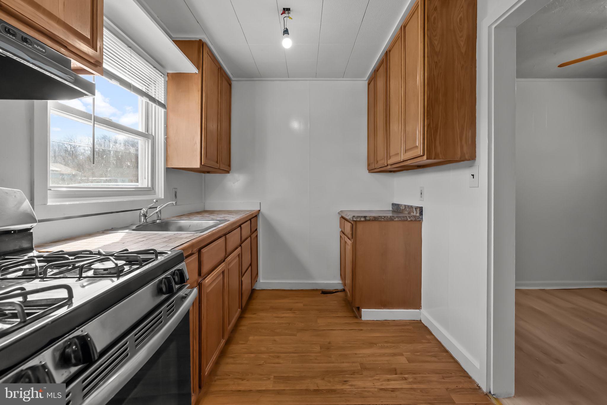 5708 Mitchell Road Levittown, PA 19057 - Photo 5 of 23 a kitchen with stainless steel appliances granite countertop a stove and a refrigerator