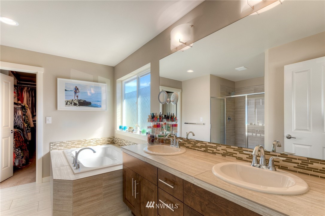 26 175th Place Southwest Bothell, WA 98012 - Photo 17 of 27 a bathroom with a granite countertop tub a double vanity sink and a large mirror