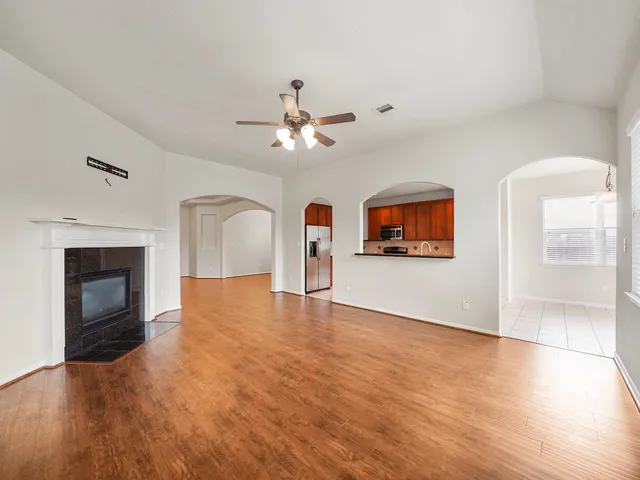 an empty room with windows and fireplace