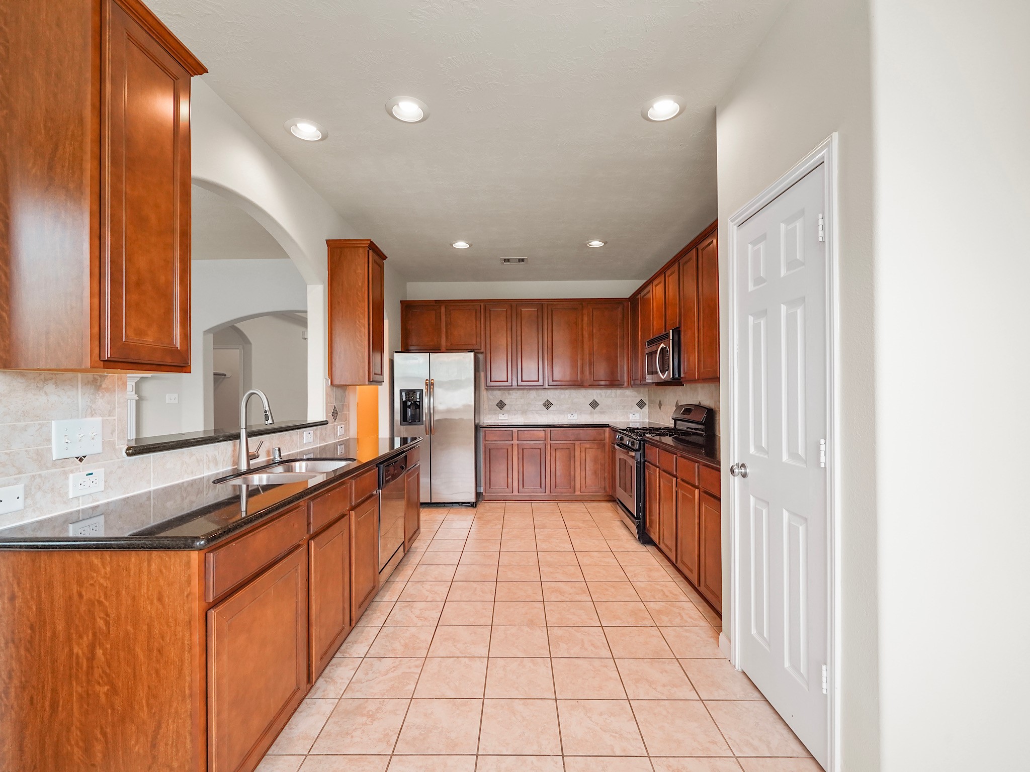 3218 Bandera Run Lane Katy, TX 77494 - Photo 6 of 15 STUNNING kitchen features granite countertops, rich wood cabinets, tile backsplash and stainless steel appliances!