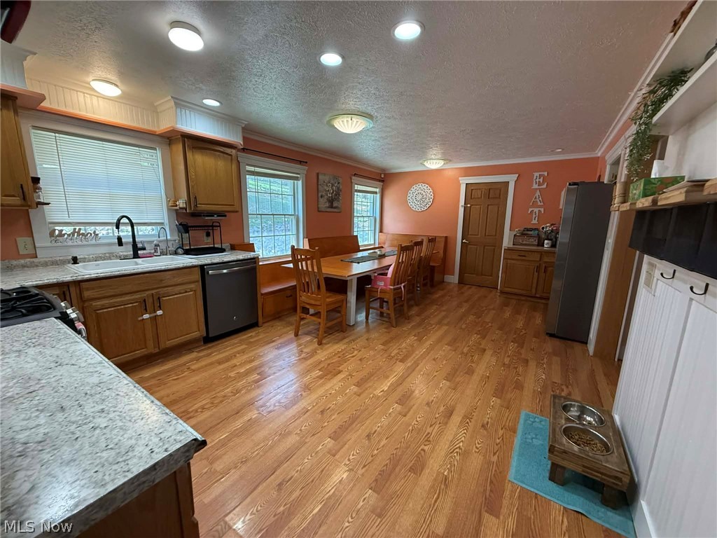 7170 Old Town Road Mount Perry, OH 43760 - Photo 8 of 41 Kitchen with a textured ceiling, freestanding refrigerator, gas stove, ornamental molding, and dishwasher