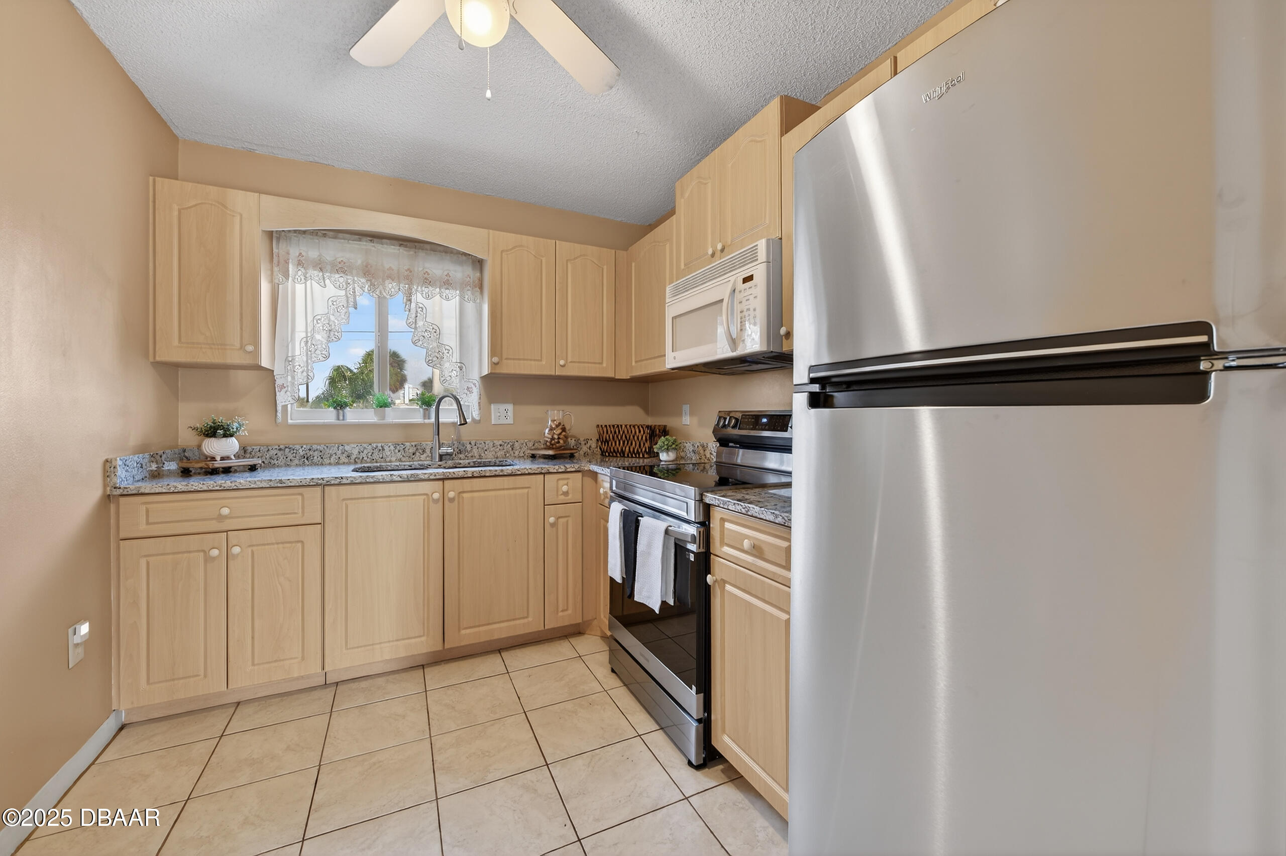 2711 North Halifax Avenue, Unit 282 Daytona Beach, FL 32118 - Photo 6 of 18 a kitchen with white cabinets and white appliances