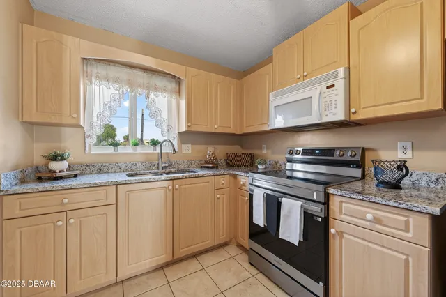 a kitchen with granite countertop white cabinets and white appliances